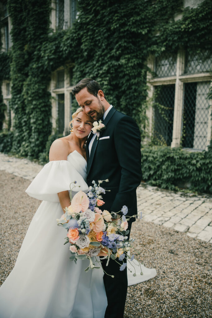 Brudepar ved en historisk bygning med fransk stemning